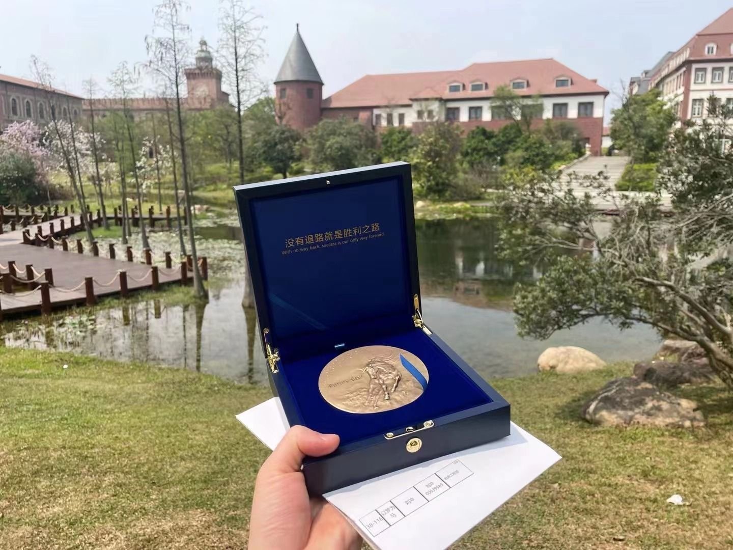 The Huawei Future Star medal in its blue presentation box, held up outdoors